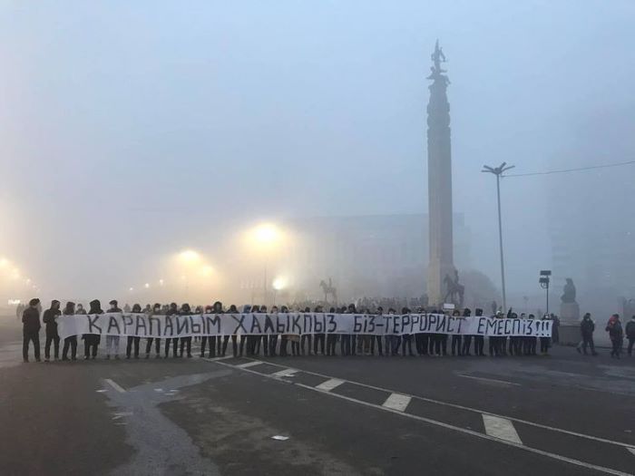 Demonstrace na náměstí Republiky v Almaty 6. ledna 2022. Na plakátu stojí "Jsme obyčejný lid, nejsme teroristé!" Foto Amir Shaikezhanov